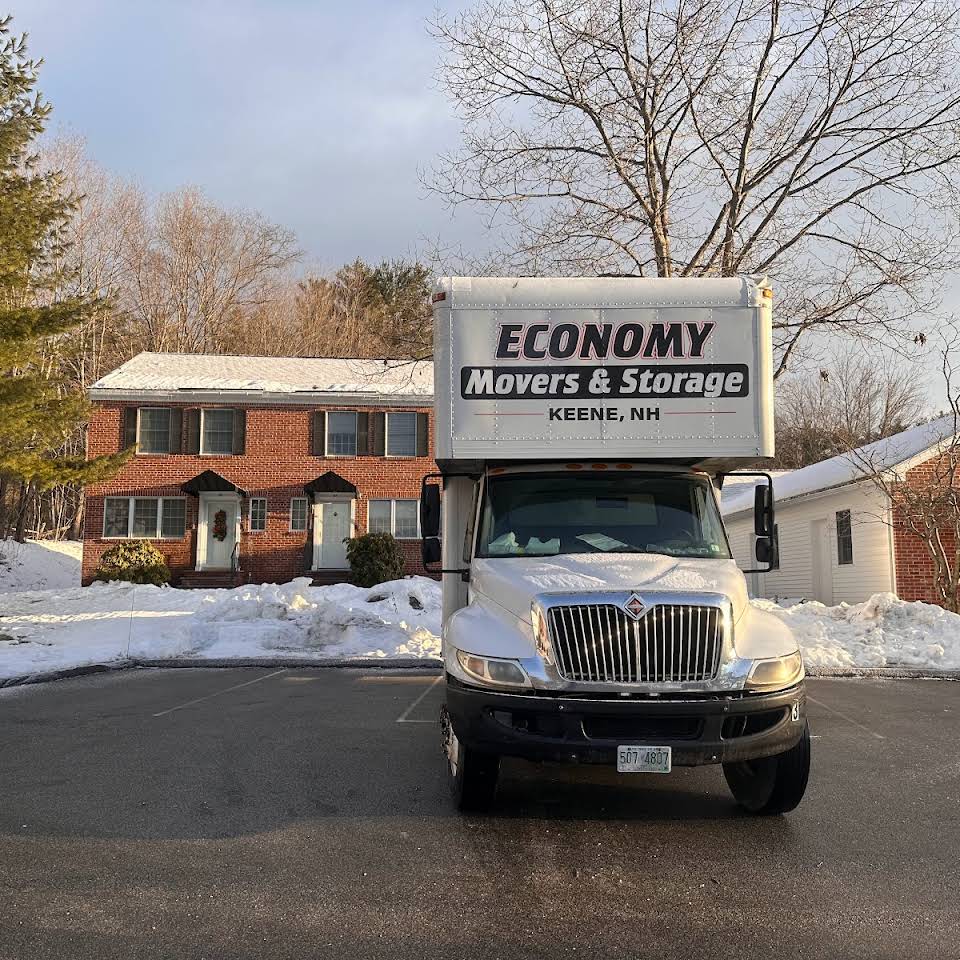 Economy Movers truck outside of red brick building with snow on the ground