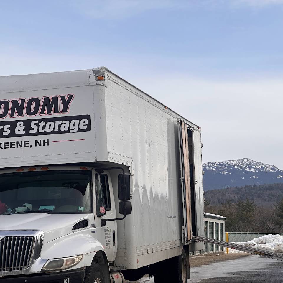 Economy Movers truck parked on a road in front of a snowy mountain top