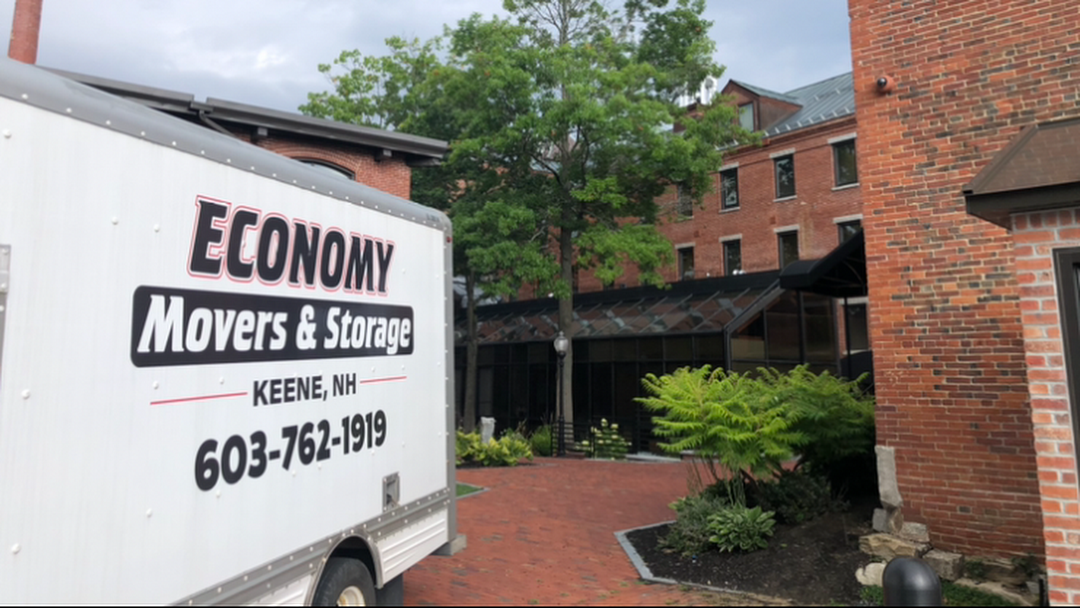 Economy Movers & Storage truck parked in a driveway at a business complex.